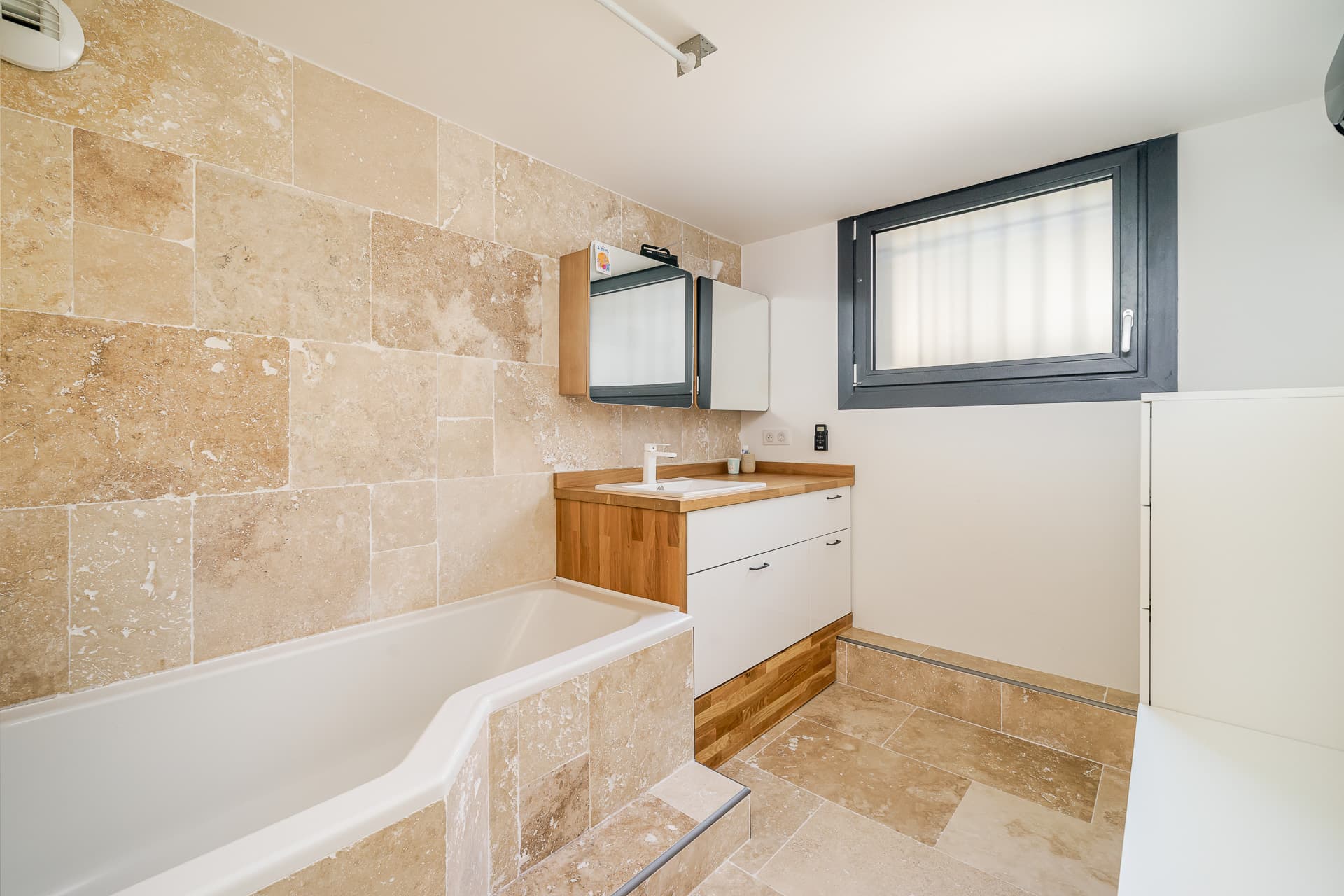 Salle de bain en travertin avec baignoire
